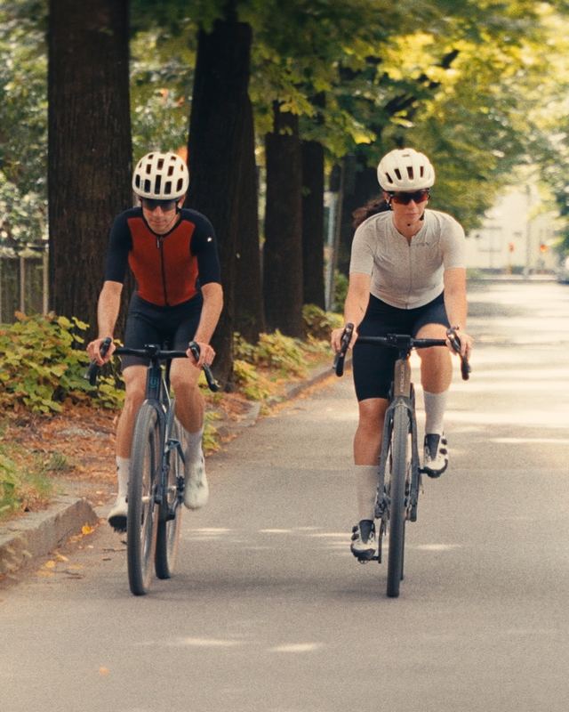 Due ciclisti gravel su strada alberata