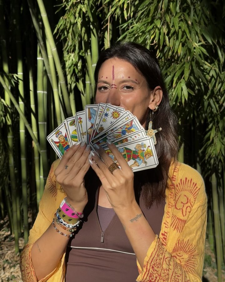 Cappuccino Yoga con un ventaglio di tarocchi di Marsiglia davanti ai bambù