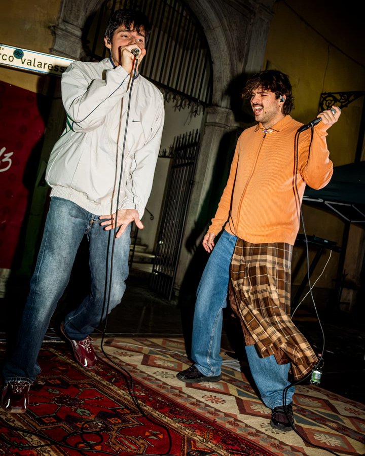 Il gruppo live in concerto di sera davanti a un portale di pietra