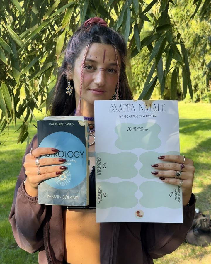 Lilly di Cappuccino Yoga con un libro di astrologia e la mappa natale